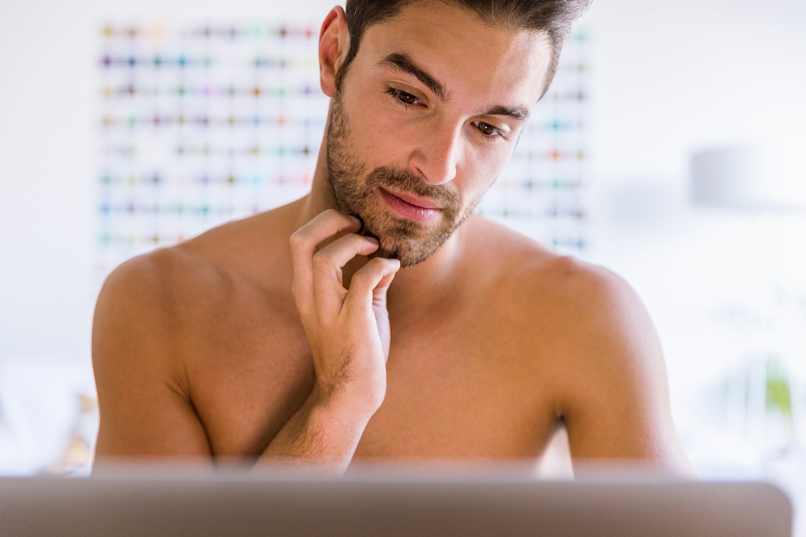 Shirtless man met laptop