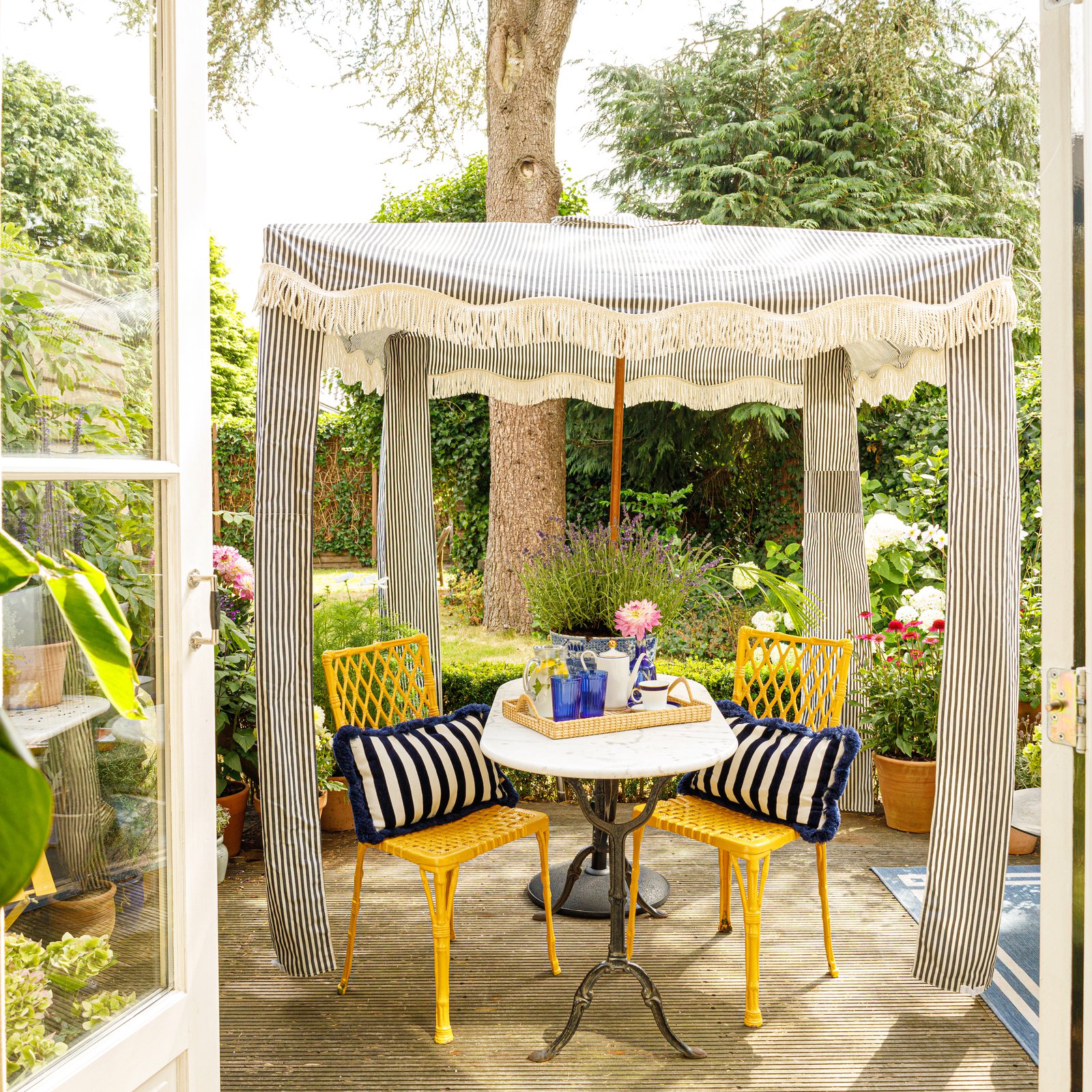 Het zonnige terras kijkt uit op een ruime tuin die Roel deelt met zijn huurbaas.